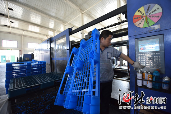 
            	文安经济开发区智能电网产业园河北伯爵塑料制品有限公司工作人员取出塑料托盘。 王晖摄9月4日，廊坊文安经济开发区智能电网产业园国电远鹏能源科技股份有限公司项目施工现场一片忙碌