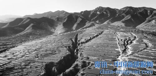                                                                                                                                                 
	蓝色的光伏发电板铺满了山坡。图为芮城协鑫光伏发电场址全景