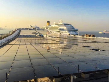 　　薄膜太阳能组件直接铺设于上海吴淞口国际邮轮港客运楼楼顶　　当清晨的第一抹阳光洒在客运楼的屋顶上，通过这片一万平方米的薄膜太阳能电池板，太阳能源源不断地转为电能，在完成直流电向交流电的转换后，清洁电能被用于客运楼的日常供电，部分实现上网销售。　　在上海吴淞口国际邮轮港，去年年底建成的“屋顶电站”已经投用，每月贡献发电量9万多度