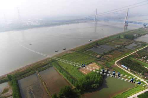 
                        

準東—皖南特高壓長江大跨越工程現(xiàn)場。
　　4月15日，在安徽省無為縣高溝鎮(zhèn)長江北岸，一排排導(dǎo)線在張力機作用下緩緩向長江南岸牽引場釋放