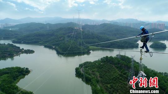 　　電網(wǎng)工人在百米高空進(jìn)行工程安裝作業(yè)。　沈甸　攝　　南方電網(wǎng)廣東東莞縱江變電站配套500千伏線路二期工程6月28日竣工投運(yùn)