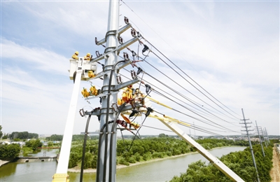                                     　　            　　6月26日午間13時20分，合肥電網(wǎng)最大負荷攀升至556.8萬千瓦，今夏首次打破6月歷史紀錄，合肥電網(wǎng)自此全面進入迎峰度夏期間。圖為合肥供電公司人員在肥東縣臨河路10千伏電桿上冒高溫開展帶電作業(yè)