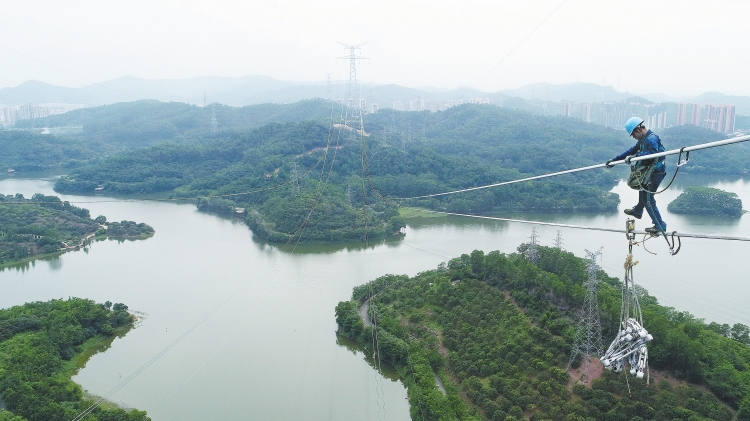 　　500千伏縱江二期工程投運 　　珠三角負荷中心供電能力“再升級” 　　高空作業(yè)人員在離水面近百米的空中安裝間隔棒。陳海東 攝　　6月28日，廣東東莞縱江變電站配套500千伏線路二期工程(以下簡稱“縱江二期工程”)竣工投運